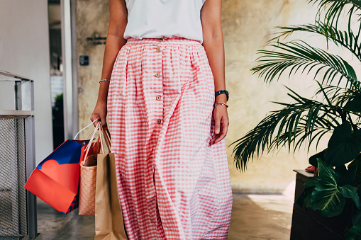 An anonymous female Asian shopaholic carrying shopping bags after buying some things at a store.