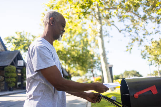 istock Senior black man mailing ballot for election 1397791143