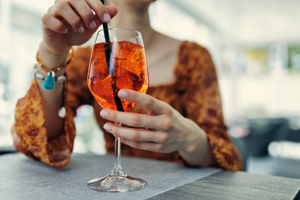 jovem desfrutando de coquetel italiano spritz em restaurante. - refreshment drink drinking straw cocktail - fotografias e filmes do acervo