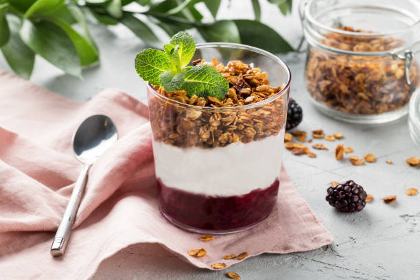 Parfait with yogurt, granola, jam and fresh berries in the glass jar. Healthy dessert or snack. stock photo