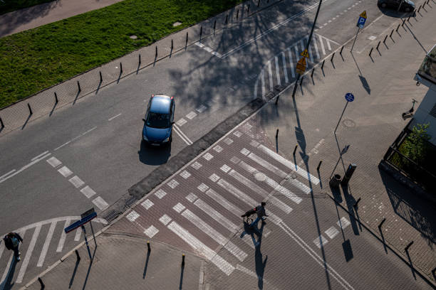 Warsaw, Poland- 05.02.2022: Pedestrian crossing on the paved road. Top view. The car stopped to pass a pedestrian.