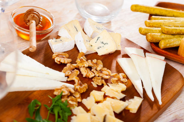 istock Cheese slices on wooden board with honey, walnuts, arugula 1397797291