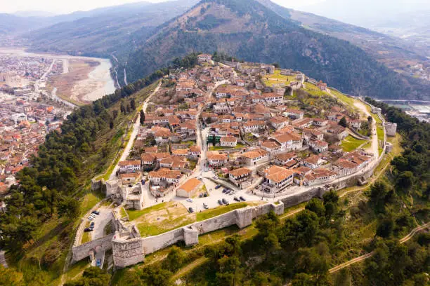 Scenic aerial view of historical area of Albanian city of Berat on hilltop surrounded by fortified walls of ruined medieval castle on spring day