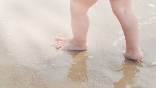 istock The baby's feet stomp on the wet sea coast 1397797982
