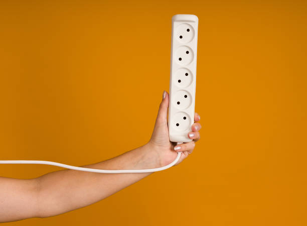 istock white electrical extension cord with sockets in hand on yellow background 1397798832