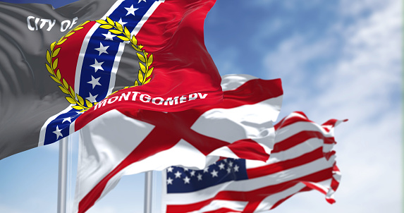 The flag city of Montgomery waving in the wind with the flags of Alabama state and United States of America. Democracy and independence. Montgomery is the capital city of the U.S. state of Alabama