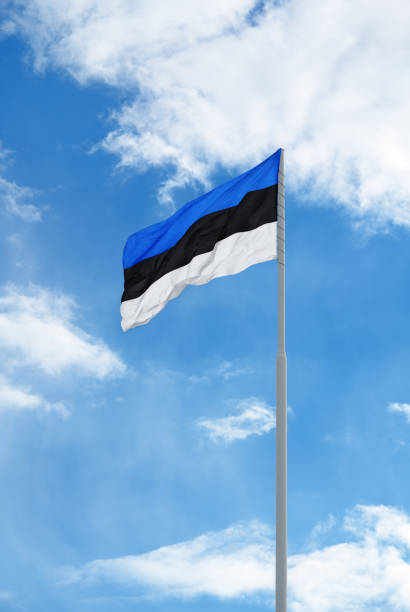 istock Estonian flag in front of blue sky and clouds. 1397800947