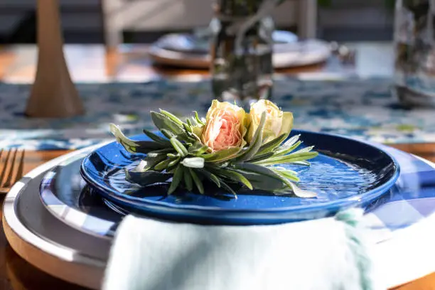 Rose buds on a blue luncheon plate in a dining room decorated for spring