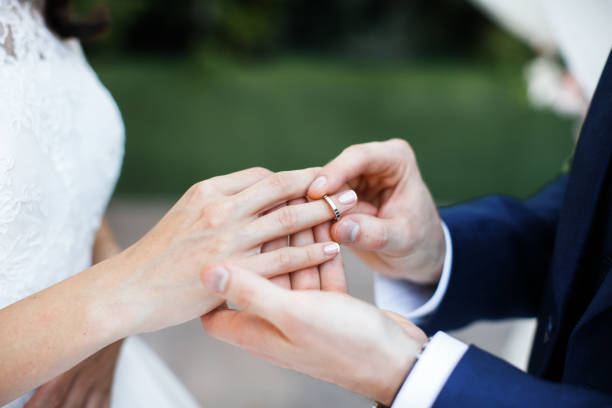 istock Groom wears ring on bride's finger 1397802741
