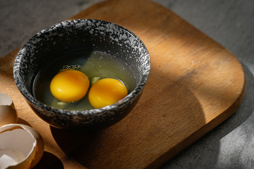 Close up image of three eggs yolk in clear bowl are one of the food ingredients on the restaurant table in the kitchen to prepare for cooking. Organic chicken eggs food ingredients concept