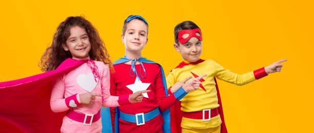 istock Happy superhero kids pointing away in studio 1397808929