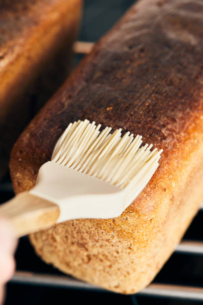 le processus de fabrication du pain moulé au seigle. enrober le pain fini de gelée d’amidon. - polish bread photos et images de collection