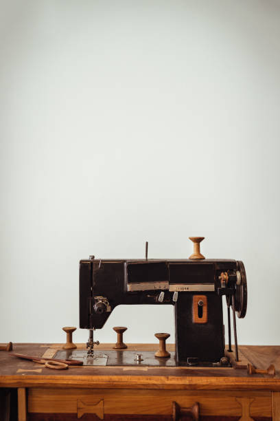 istock Old vintage sewing machine on wooden table on white wall background. 1397809324