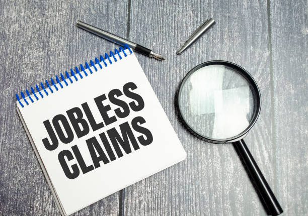Jobless claims text on white paper from a notepad on a wooden background. stock photo