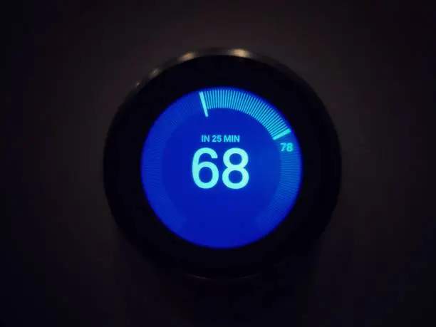 Photo of The temperature on modern circle thermostat in black background