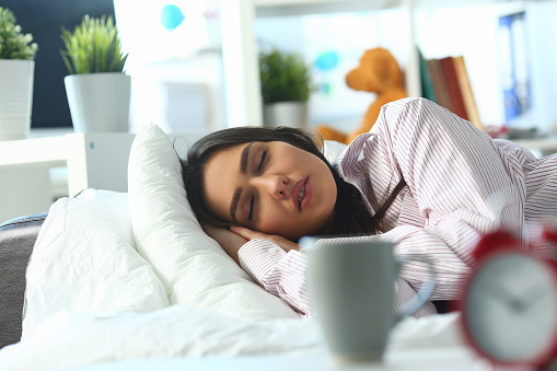 Portrait of young woman peacefully sleeping in bed, tired female, tough night, sleepless. Lady in pyjamas at home, early start. Good morning, awake concept