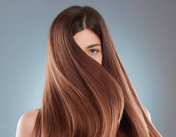긴 갈색 머리카락을 과시하는 아름다운 젊은 여성의 스튜디오 샷 - 털 뉴스 사진 이미지
