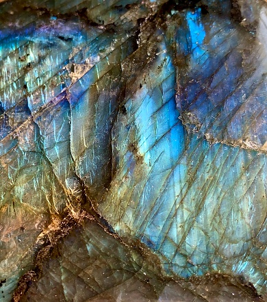 Extreme close-up of mosaic opal earring on a black slate.