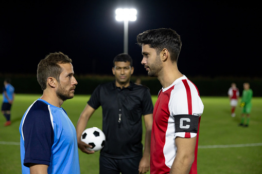 Competitive soccer players facing each other and looking ready for the kick off - sports competition concepts