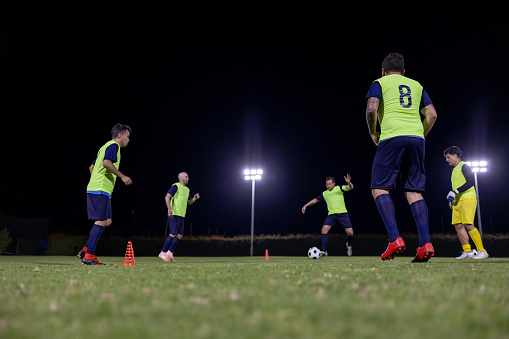 Latin American soccer team in practice at night and wearing training bibs - sports concepts