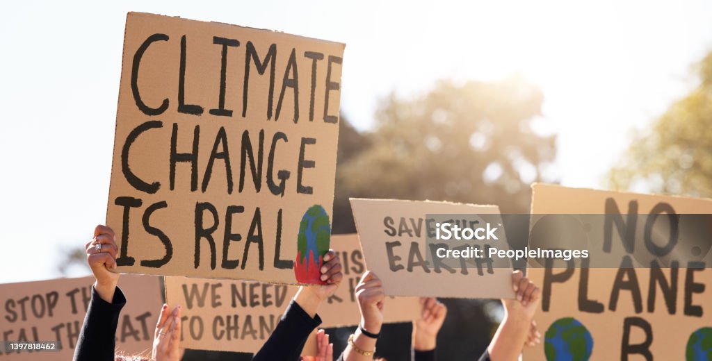 Shot of a group of people protesting climate change We will not be silenced Climate Change Stock Photo
