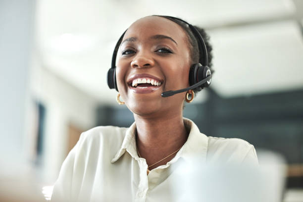 shot of an attractive young call centre agent sitting alone in the office - african descent customer service representative computer service imagens e fotografias de stock