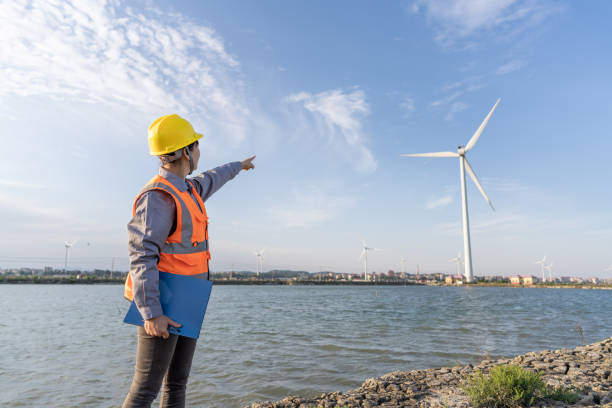 An Asian wind power engineer checks wind power data at the seaside