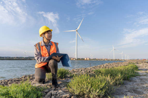 istock An Asian female engineer squatted on the beach to check the wind turbine data 1397819325