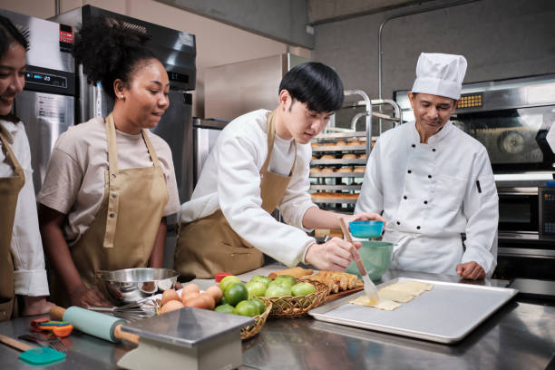 istock Senior chef teaches cooking students to prepare pastry dough for fruit pies. 1397826765