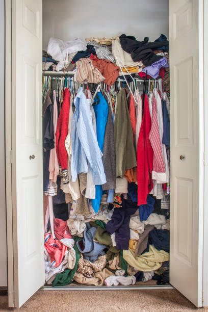 messy closet overfilled with clothes stock photo