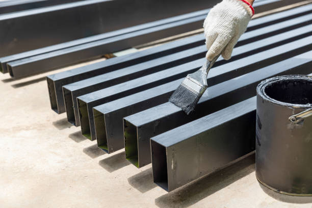 Worker painting steel post in construction site. Worker painting steel post in construction site. rustproof stock pictures, royalty-free photos & images