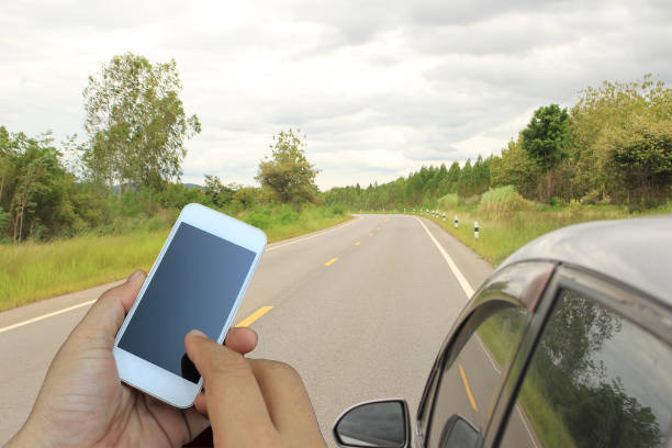 istock hand holding the smartphone on road running through the way 1397834747