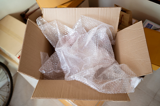 An opened cardboard box with bubble wrap inside