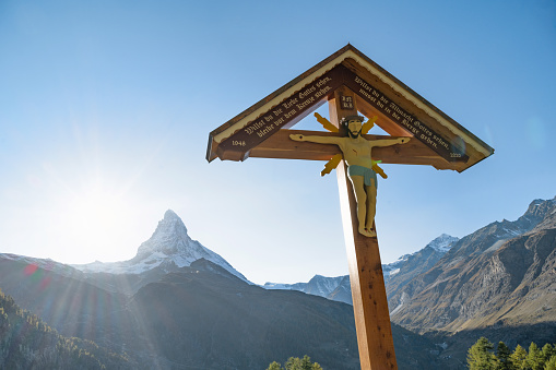 Zermatt, Switzerland – October 14: wooden holy cross in front of Matterhorn in the backlit of the swiss alps