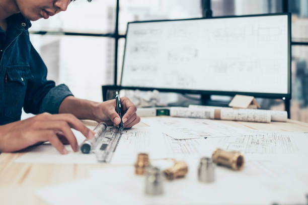 istock Architect engineer use pen  and mini T-slide drawing design working on blueprint. House planning design and construction concept. 1397837293