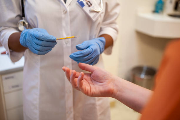 Close up shot of healthcare worker's gloved hands holding blister pack of medication stock photo