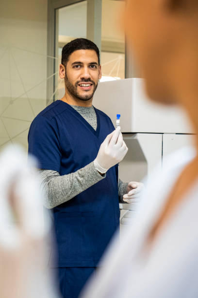 joven enfermero latinoamericano sosteniendo vial en centro de salud - nurse doctor healthcare and medicine latin american and hispanic ethnicity fotografías e imágenes de stock