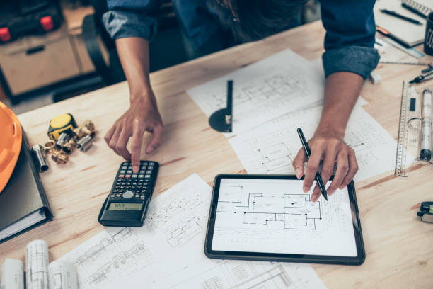 Architect engineer use calculator for calculate drawing design working on blueprint. House planning design and construction concept. stock photo