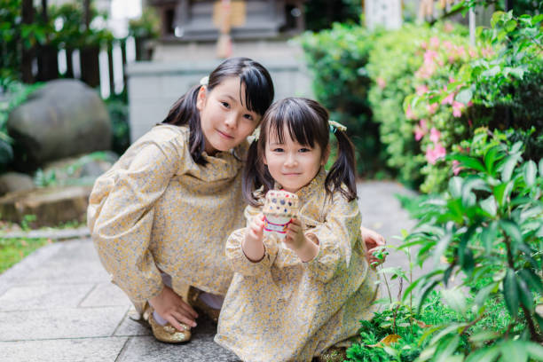 kleine mädchen, die glücklich draußen spielen - people child twin smiling stock-fotos und bilder