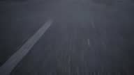 istock close-up cinematic POV shot of an wet asphalt road. Car or motorcycle is driving on the highway 1397841517