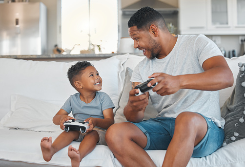 Foto de un joven jugando videojuegos con su hijo en casa photo