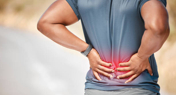 photo d’un homme méconnaissable debout seul à l’extérieur et souffrant de maux de dos pendant sa course - human muscle back muscular build men photos et images de collection