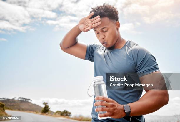 Shot Of A Man Drinking Water While Out For A Workout Stock Photo - Download Image Now