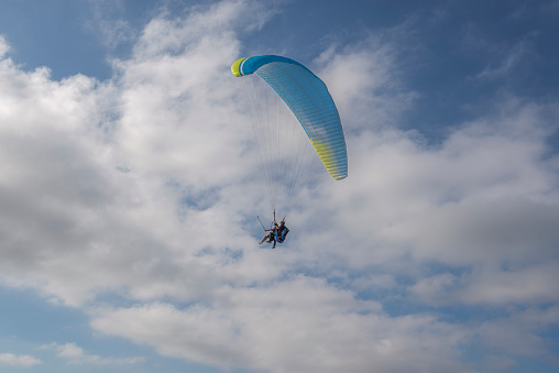 Es Mercadal, Spain - August 7, 2021: First flight with a tandem paragliding instructor. Photo taken from the El Toro lookout point, municipality of Es Mercadal, Menorca, Spain