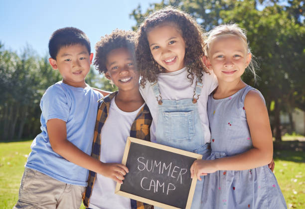 foto de un grupo de amigos sosteniendo un cartel en un exterior de un parque - campamento de verano fotografías e imágenes de stock