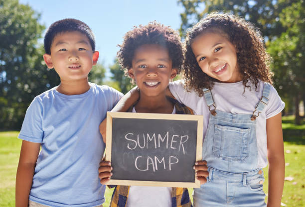 ujęcie grupy przyjaciół trzymających znak na zewnątrz w parku - summer camp sign child summer zdjęcia i obrazy z banku zdjęć