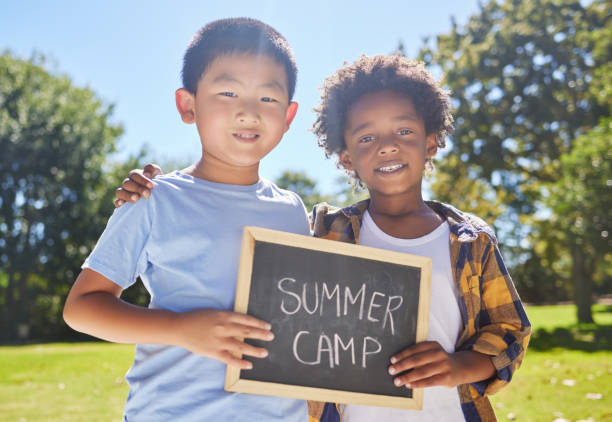 ujęcie dwóch przyjaciół trzymających znak na zewnątrz w parku - summer camp sign child summer zdjęcia i obrazy z banku zdjęć
