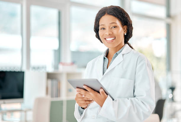 Portrait of a young scientist using a digital tablet in a lab Let's make some real discoveries laboratory coat stock pictures, royalty-free photos & images