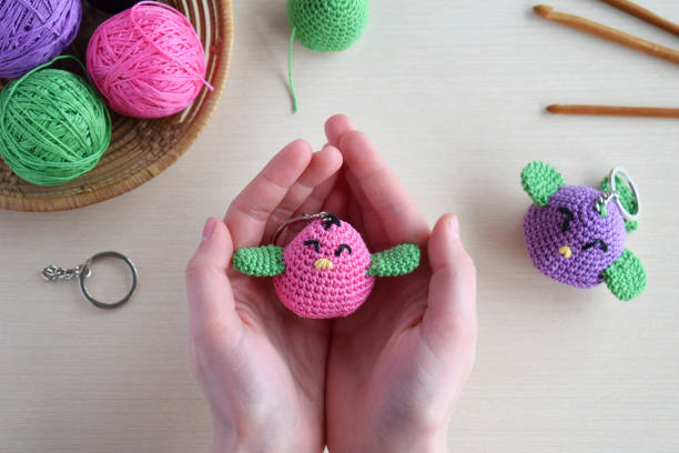 istock Making colored crochet bird. Toy for babies or trinket.  On the table threads, needles, hook, cotton yarn. Handmade gift. DIY crafts concept. 1397844821