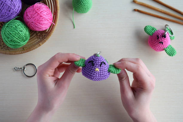 istock Making colored crochet bird. Toy for babies or trinket.  On the table threads, needles, hook, cotton yarn. Handmade gift. DIY crafts concept. 1397844832